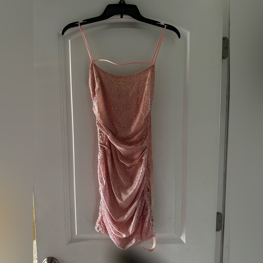 Woman light pink sequin “going out dress”. Spaghetti straps mini
